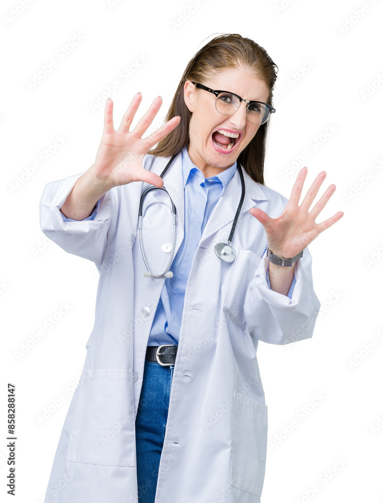 Middle age mature doctor woman wearing medical coat over isolated background afraid and terrified with fear expression stop gesture with hands, shouting in shock. Panic concept.