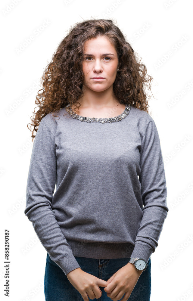 Beautiful brunette curly hair young girl wearing a sweater over isolated background with serious expression on face. Simple and natural looking at the camera. Beautiful brunette curly hair young girl wearing a sweater over isolated background with serious expression on face. Simple and natural looking at the camera.