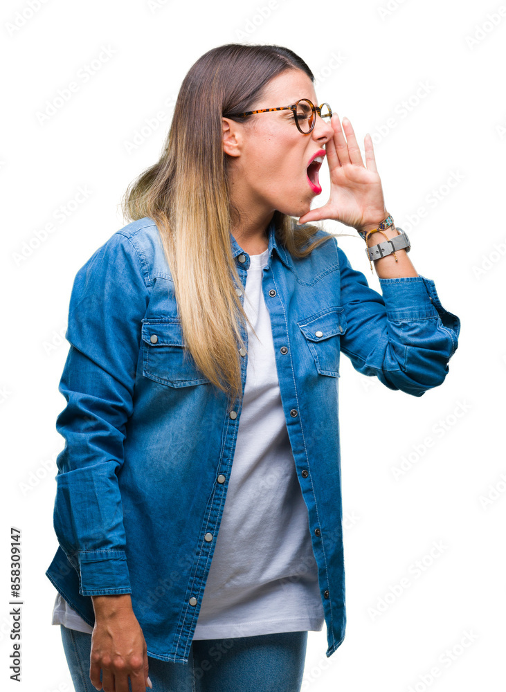 Young beautiful woman over wearing glasses over isolated background shouting and screaming loud to side with hand on mouth. Communication concept. Young beautiful woman over wearing glasses over isolated background shouting and screaming loud to side with hand on mouth. Communication concept.