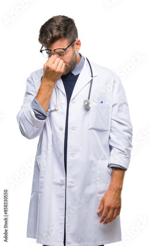 Young handsome doctor man over isolated background tired rubbing nose and eyes feeling fatigue and headache. Stress and frustration concept.