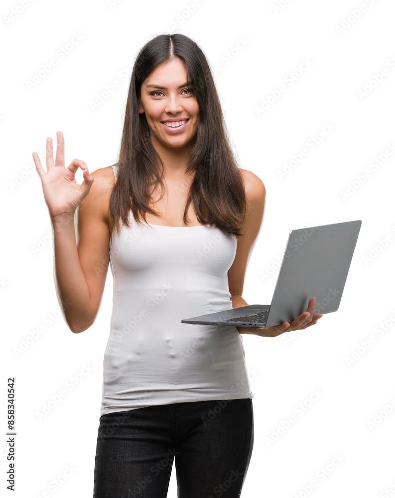 Young hispanic woman using computer laptop doing ok sign with fingers, excellent symbol