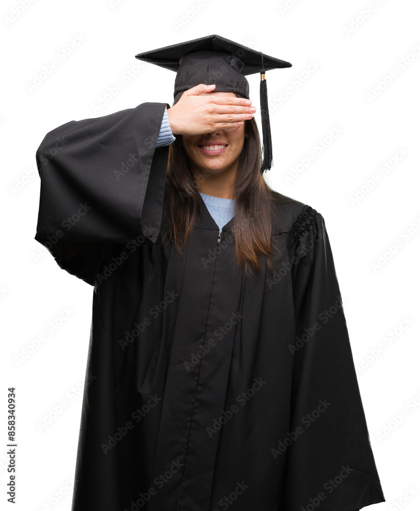 Young hispanic woman wearing graduated cap and uniform smiling and laughing with hand on face covering eyes for surprise. Blind concept. Young hispanic woman wearing graduated cap and uniform smiling and laughing with hand on face covering eyes for surprise. Blind concept.