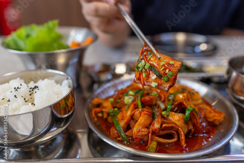 woman use chopstick eating Korean cuisine, Kimchi pork stir-fry with vegetables served with a side of steamed white rice topped with black sesame seeds, asian food culture