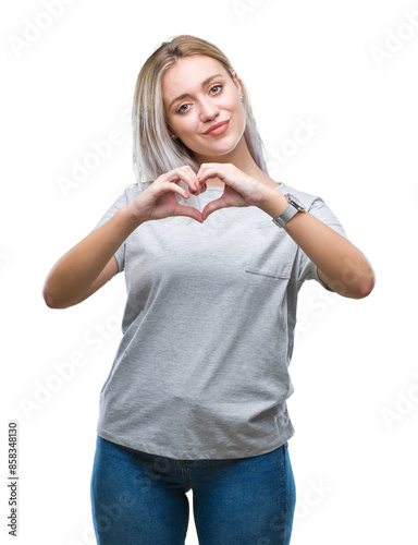 Young blonde woman over isolated background smiling in love showing heart symbol and shape with hands. Romantic concept.