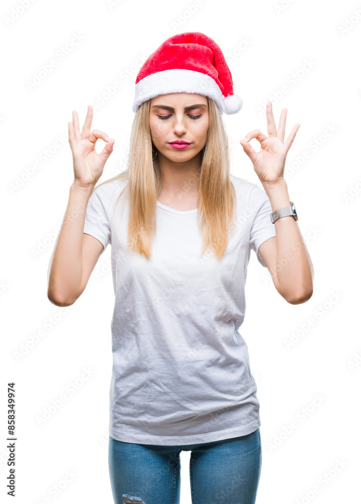 Young beautiful blonde woman christmas hat over isolated background relax and smiling with eyes closed doing meditation gesture with fingers. Yoga concept. Young beautiful blonde woman christmas hat over isolated background relax and smiling with eyes closed doing meditation gesture with fingers. Yoga concept.