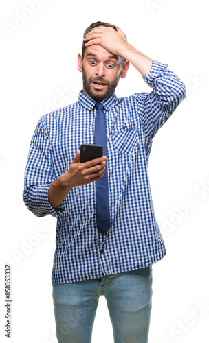 Young hadsome man texting sending message using smartphone over isolated background stressed with hand on head, shocked with shame and surprise face, angry and frustrated. Fear and upset for mistake. photo