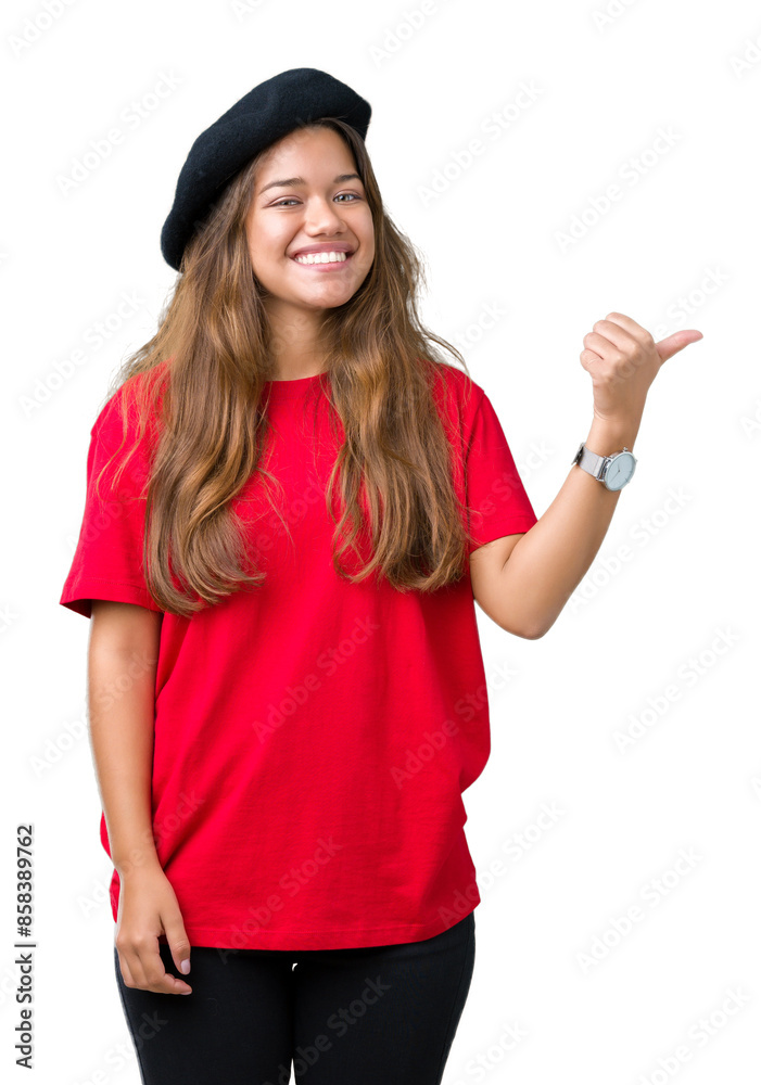 Young beautiful brunette fashion woman wearing red t-shirt and black beret over isolated background smiling with happy face looking and pointing to the side with thumb up. Young beautiful brunette fashion woman wearing red t-shirt and black beret over isolated background smiling with happy face looking and pointing to the side with thumb up.