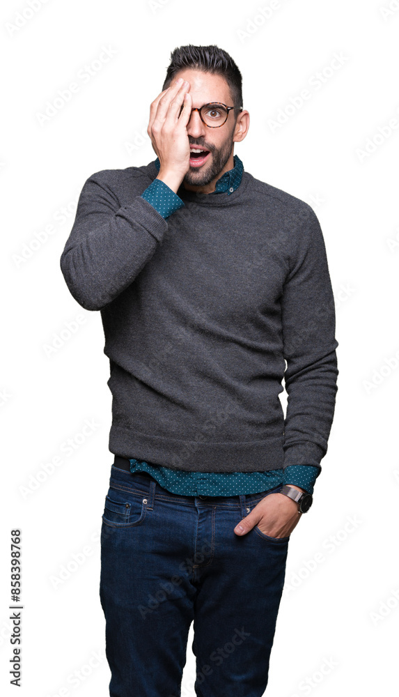 Young handsome man wearing glasses over isolated background covering one eye with hand with confident smile on face and surprise emotion. Young handsome man wearing glasses over isolated background covering one eye with hand with confident smile on face and surprise emotion.