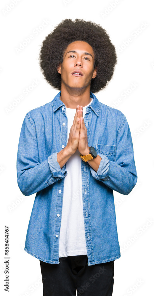 Young african american man with afro hair begging and praying with hands together with hope expression on face very emotional and worried. Asking for forgiveness. Religion concept. Young african american man with afro hair begging and praying with hands together with hope expression on face very emotional and worried. Asking for forgiveness. Religion concept.