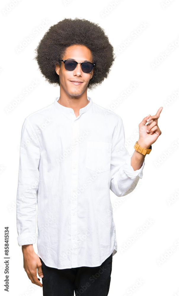 Young african american man with afro hair wearing sunglasses with a big smile on face, pointing with hand and finger to the side looking at the camera. Young african american man with afro hair wearing sunglasses with a big smile on face, pointing with hand and finger to the side looking at the camera.