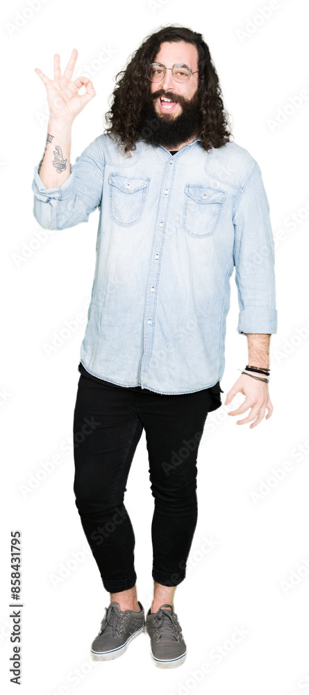 Obraz premium Young hipster man with long hair and beard wearing glasses smiling positive doing ok sign with hand and fingers. Successful expression.