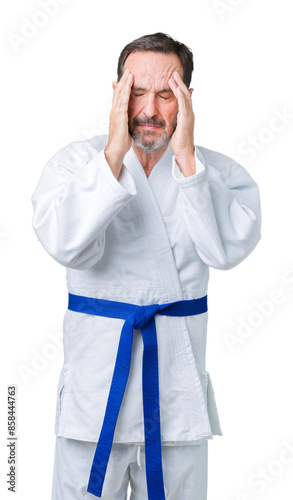 Handsome middle age senior man wearing kimono uniform over isolated background with hand on head for pain in head because stress. Suffering migraine.