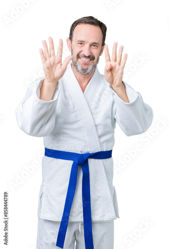 Handsome middle age senior man wearing kimono uniform over isolated background showing and pointing up with fingers number nine while smiling confident and happy.