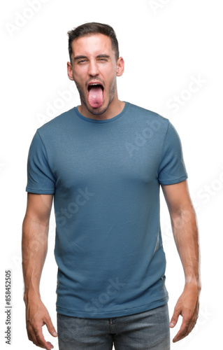 Handsome young casual man sticking tongue out happy with funny expression. Emotion concept.