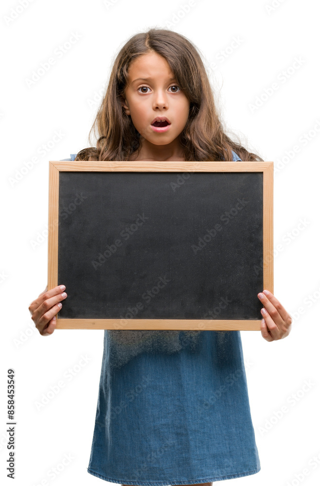 Brunette hispanic girl holding blackboard scared in shock with a surprise face, afraid and excited with fear expression Brunette hispanic girl holding blackboard scared in shock with a surprise face, afraid and excited with fear expression