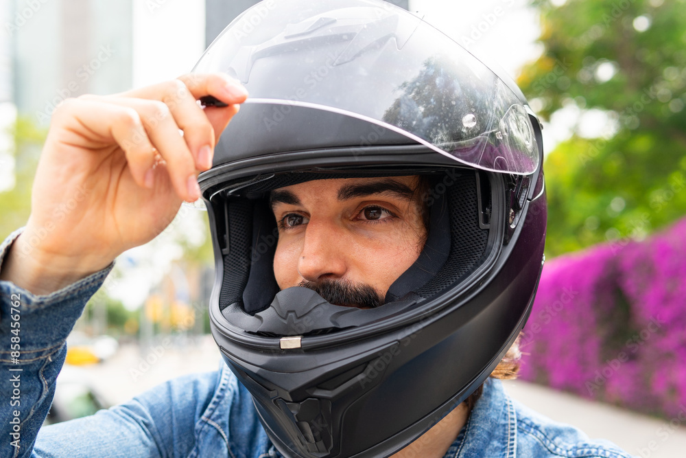 Young man adjusting helmet in urban setting Young man adjusting helmet in urban setting
