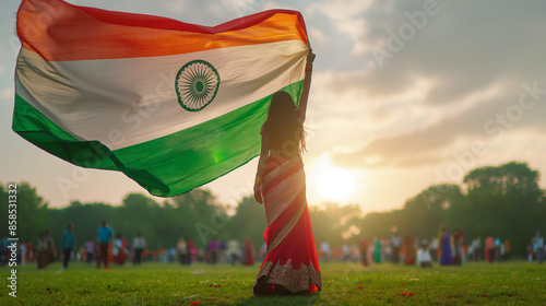 Woman holding huge Indian flag fluttering proudly in the wind photo