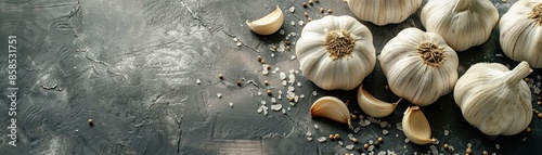 Fresh garlic bulbs and cloves on a dark textured background. Culinary ingredients and spices for cooking. photo