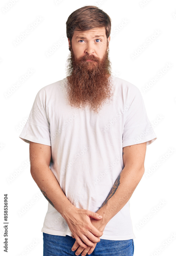 Obraz premium Handsome young red head man with long beard wearing casual white tshirt skeptic and nervous, frowning upset because of problem. negative person.