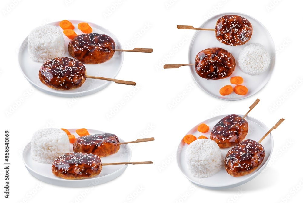 Tsukune, Japanese Chicken Meatball in teriyaki sauce with sesame seeds sprinkles with rice and vegetables in a plate on a white isolated background Tsukune, Japanese Chicken Meatball in teriyaki sauce with sesame seeds sprinkles with rice and vegetables in a plate on a white isolated background