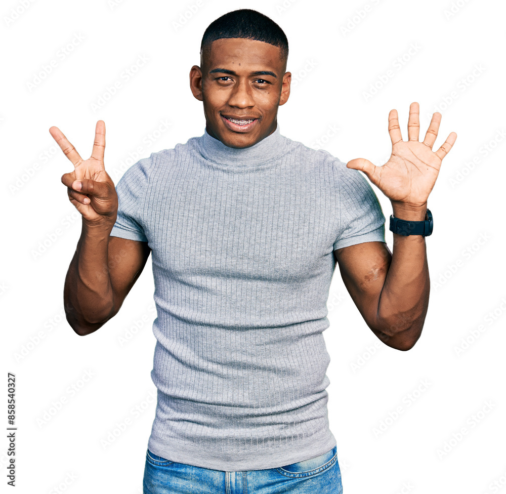 Naklejka premium Young black man wearing casual t shirt showing and pointing up with fingers number seven while smiling confident and happy.