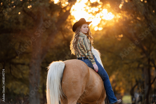Cowgirl with Palomino Quarter Horse during Golden hour photo