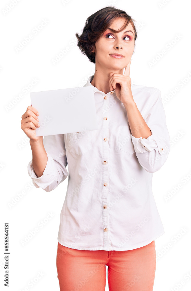 Beautiful young woman with short hair holding blank empty banner serious face thinking about question with hand on chin, thoughtful about confusing idea Beautiful young woman with short hair holding blank empty banner serious face thinking about question with hand on chin, thoughtful about confusing idea