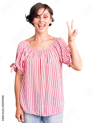 Beautiful young woman with short hair wearing casual summer clothes showing and pointing up with fingers number two while smiling confident and happy.