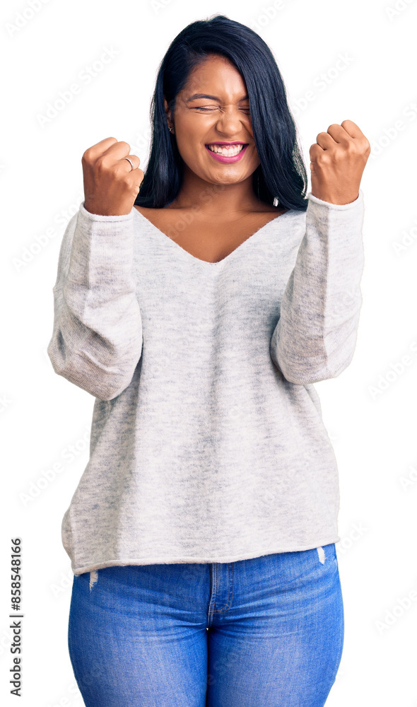 Hispanic woman with long hair wearing casual clothes excited for success with arms raised and eyes closed celebrating victory smiling. winner concept.