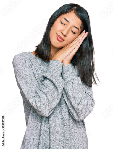 Beautiful asian young woman wearing casual clothes sleeping tired dreaming and posing with hands together while smiling with closed eyes. © Krakenimages.com