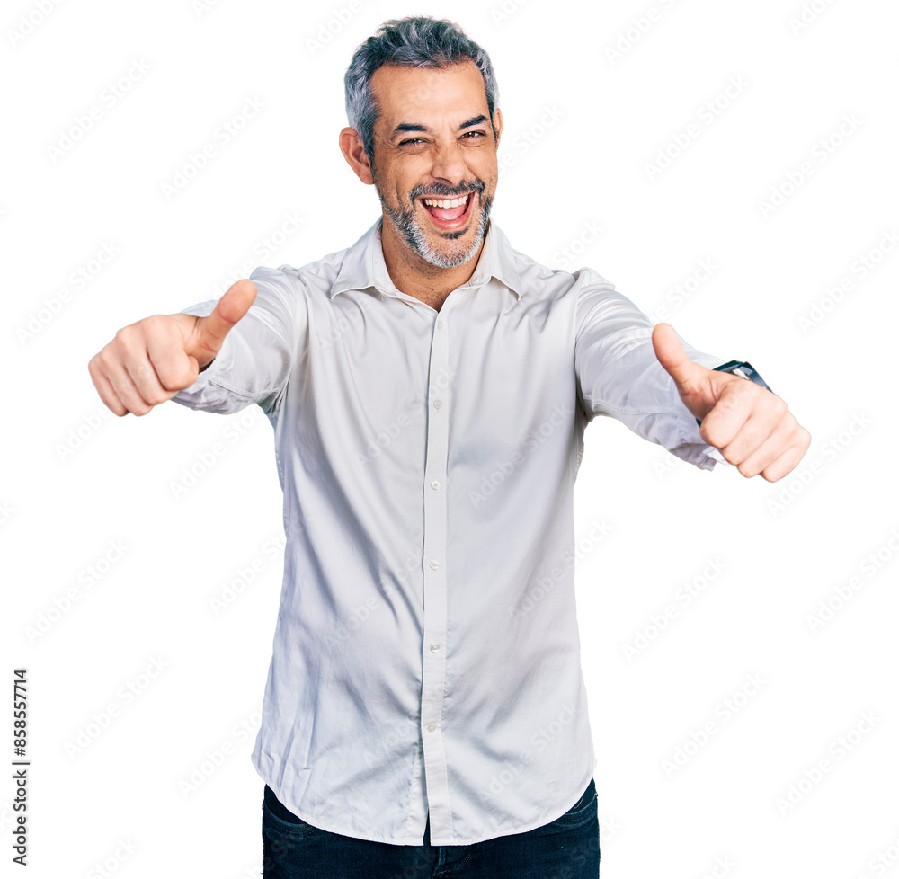 Middle age hispanic with grey hair wearing casual white shirt approving doing positive gesture with hand, thumbs up smiling and happy for success. winner gesture. Middle age hispanic with grey hair wearing casual white shirt approving doing positive gesture with hand, thumbs up smiling and happy for success. winner gesture.