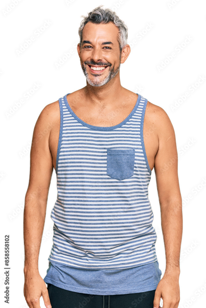 Middle age grey-haired man wearing casual style with sleeveless shirt looking positive and happy standing and smiling with a confident smile showing teeth Middle age grey-haired man wearing casual style with sleeveless shirt looking positive and happy standing and smiling with a confident smile showing teeth