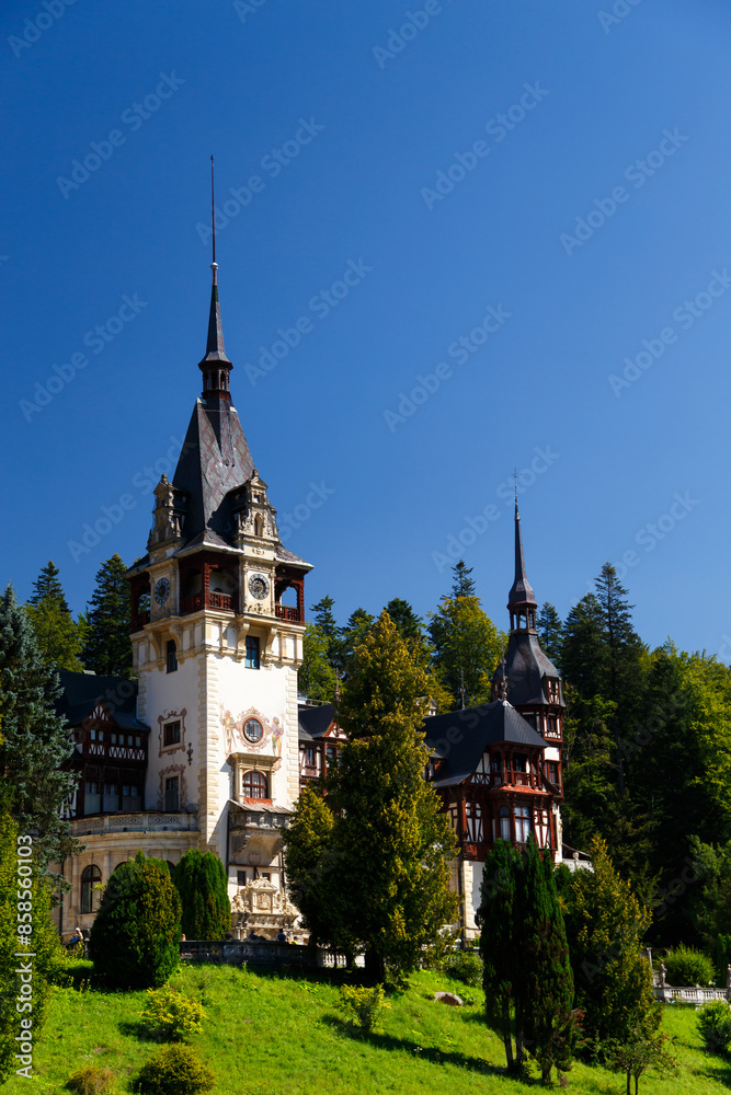 The Peles castle surrounded by splendid parklands in the town of Sinaia, Transylvania, Carpathian Mountains, Romania, Summer time, bright sunny day with dark blue sky The Peles castle surrounded by splendid parklands in the town of Sinaia, Transylvania, Carpathian Mountains, Romania, Summer time, bright sunny day with dark blue sky