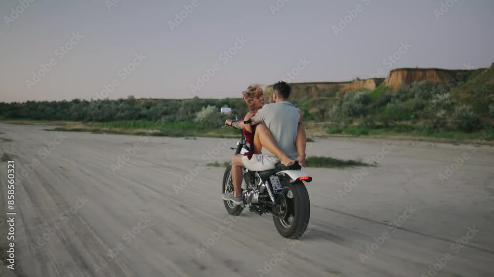 A romantic couple embraces the freedom of riding a motorcycle on the beach at sunset, enjoying an adventurous and loving moment together A romantic couple embraces the freedom of riding a motorcycle on the beach at sunset, enjoying an adventurous and loving moment together