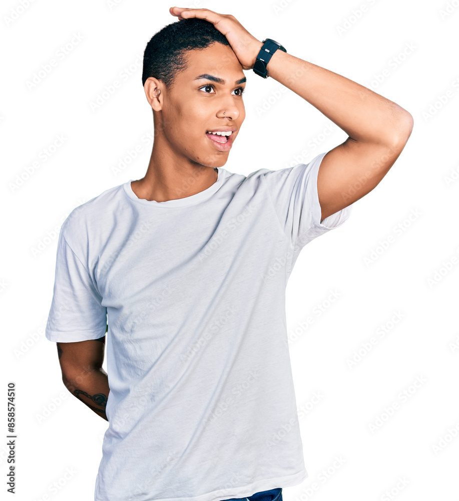 Young hispanic man wearing casual white t shirt smiling confident touching hair with hand up gesture, posing attractive and fashionable