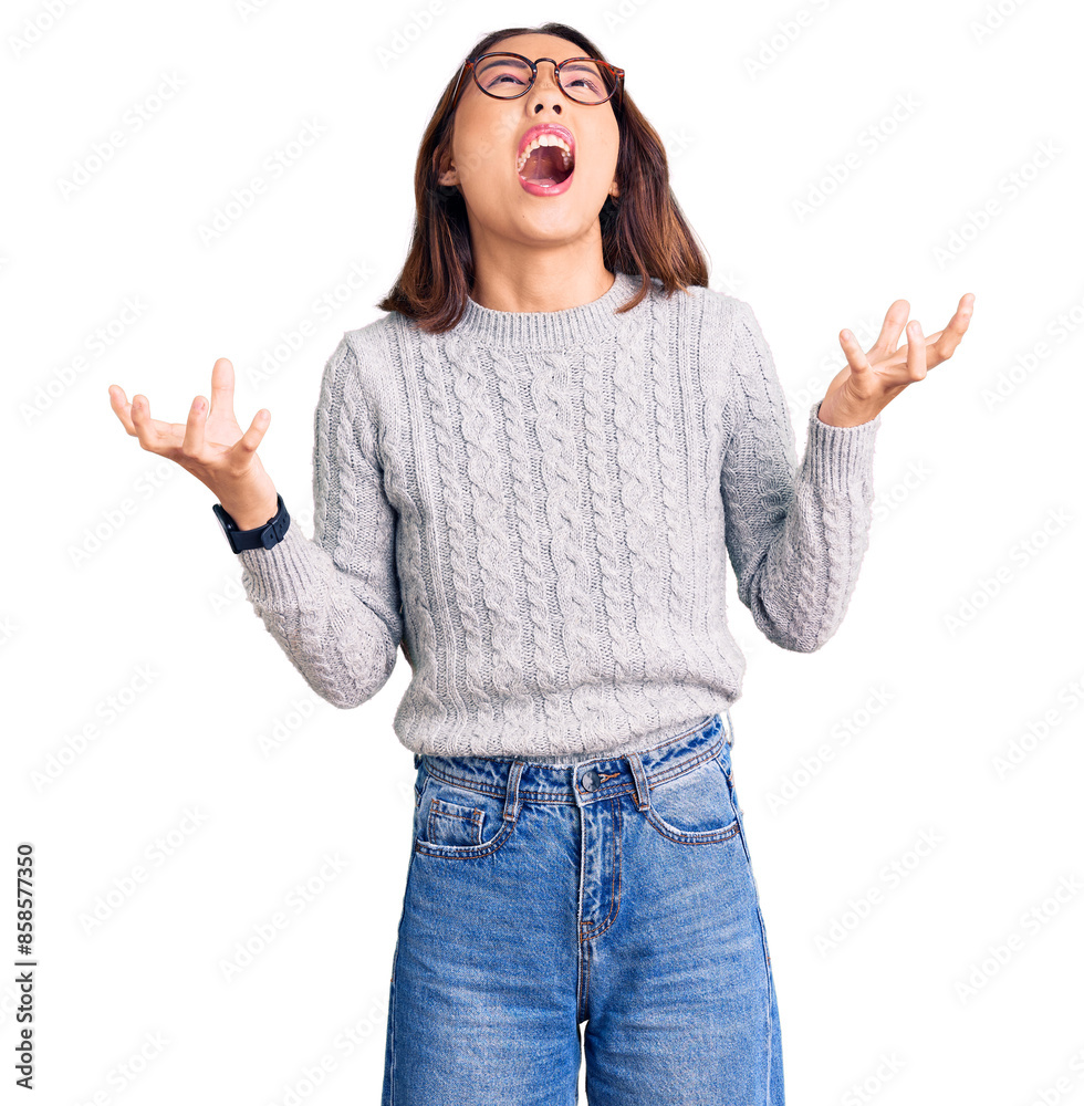 Young beautiful chinese girl wearing casual clothes crazy and mad shouting and yelling with aggressive expression and arms raised. frustration concept. Young beautiful chinese girl wearing casual clothes crazy and mad shouting and yelling with aggressive expression and arms raised. frustration concept.