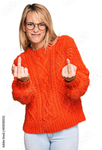 Beautiful blonde woman wearing casual clothes and glasses showing middle finger doing fuck you bad expression, provocation and rude attitude. screaming excited