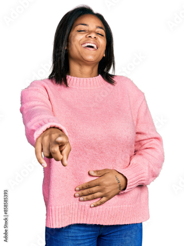 Beautiful hispanic woman wearing casual winter sweater laughing at you, pointing finger to the camera with hand over body, shame expression