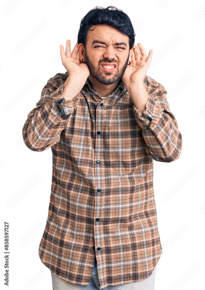 Young hispanic man wearing casual clothes trying to hear both hands on ear gesture, curious for gossip. hearing problem, deaf Young hispanic man wearing casual clothes trying to hear both hands on ear gesture, curious for gossip. hearing problem, deaf