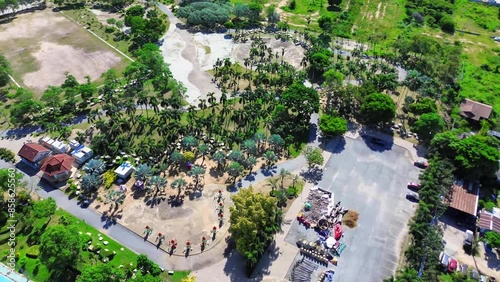Luftaufnahme eines gepflegten Parks mit Gehwegen, einem Fahrradweg, offenen Grünflächen und verschiedenen Bäumen, inklusive kleiner Gebäude und Parkplätzen in der Nähe. photo