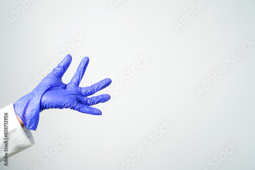 Doctor or nurse hand in sterile gloves in holding position isolated on white