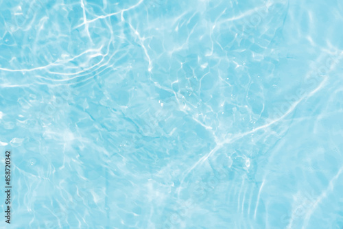 Blue water with ripples on the surface. Defocus blurred transparent blue colored clear calm water surface texture with splashes and bubbles. Water waves with shining pattern texture background.