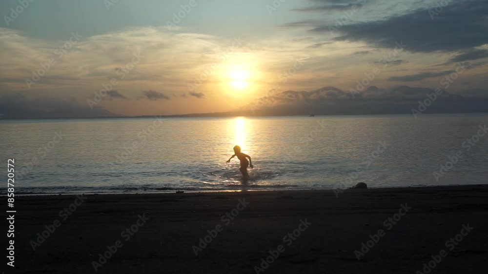Aboy is playing on the beach at sunrise. Aboy is playing on the beach at sunrise.