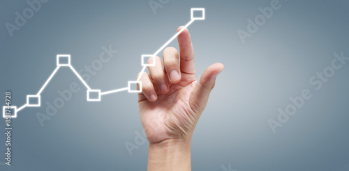 Hand touching graphs of financial indicator and accounting market economy analysis chart