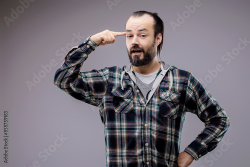 Bearded man pointing at his temple expressing thought © Giulio_Fornasar