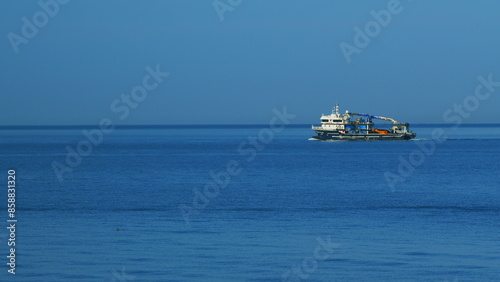 Fishing Boat Sailing In The Middle Of The Sea. Fishing Vessel Sailing Into The Sun On A Sea. Still. photo