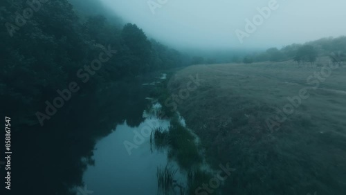 Wallpaper Mural A misty river winds through a serene meadow, encircled by lush forests, in a tranquil countryside setting Torontodigital.ca