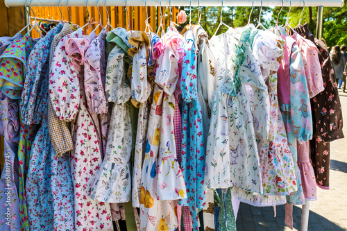 The sale of children's summer dresses at the street market. © Aleksandr Bushkov