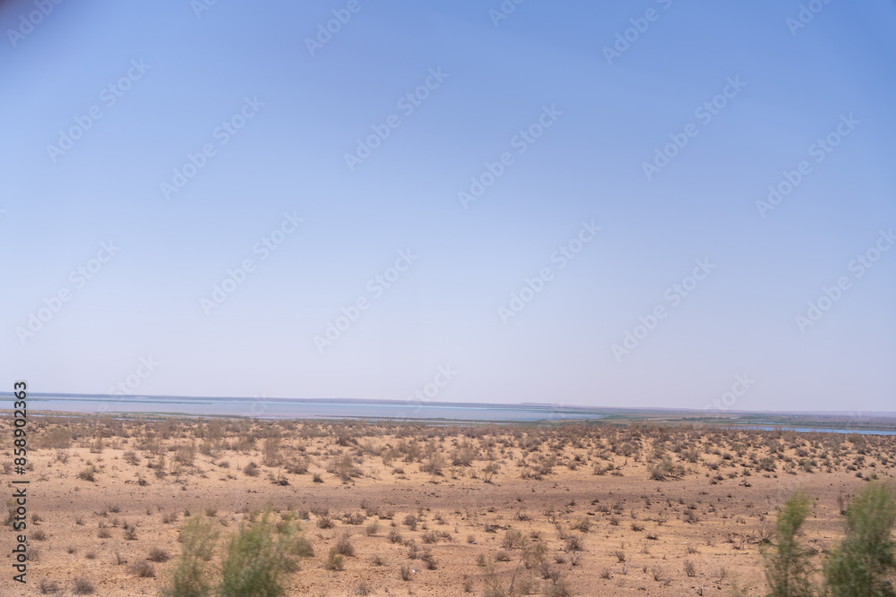A vast desert with a blue sky in the background. The sky is clear and the sun is shining brightly
