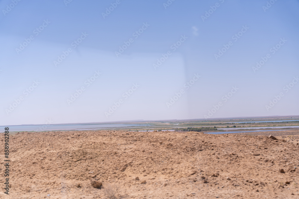 A desert landscape with a blue sky in the background. The sky is clear and the sun is shining brightly A desert landscape with a blue sky in the background. The sky is clear and the sun is shining brightly